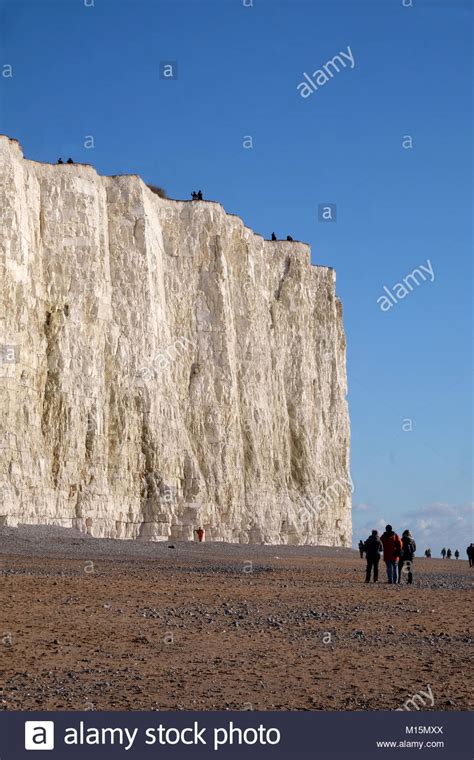 Tall White Chalk Cliff Face With A Sandy Pebble Beach At The Bottom Of