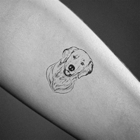 A Minimal Tattoo of a Golden Retriever's Head In Black Ink.