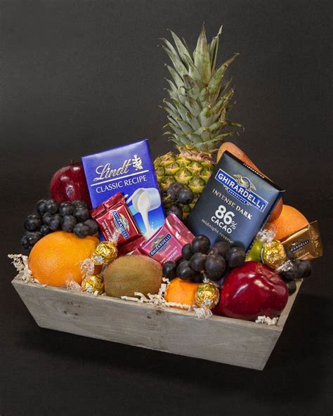 A Fruit And Chocolate Gift Basket With Pineapple Blueberries Oranges