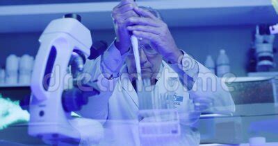 Mature Laboratory Scientist Using Dropper Or Pipette To Fill Test