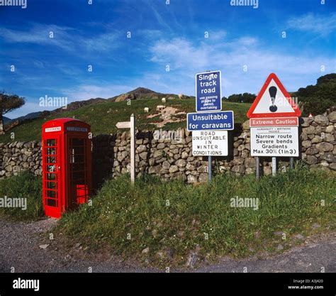 Red Telephone Box And Road Warning Signs At Foot Of Hardknott Pass In The Lake District Cumbria