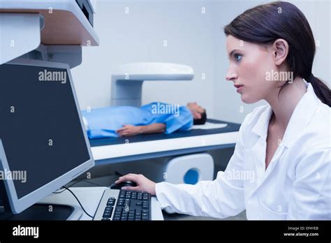 Doctor Looking Her Computer While Proceeding A Radiography Stock Photo