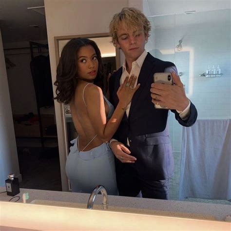 A Man Taking A Selfie In Front Of A Mirror With A Woman Standing Next To Him