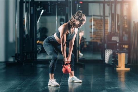 Atleta Femenina Haciendo Ejercicio Con Pesas Rusas Foto Premium