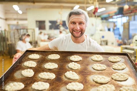 Bäcker Lehrling trägt stolz Backblech mit Hefezöpfen Stock Photo