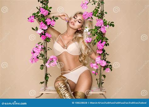 Beautiful Blonde Bride In Elegant Lingerie On A Swing Decorated With Roses Stock Photo Image