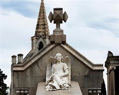 Una estatua de un ángel se sienta en una cruz en la parte superior de