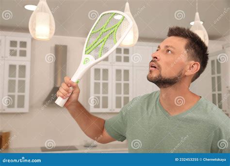 Man With Electric Fly Swatter In Kitchen Insect Killer Stock Image