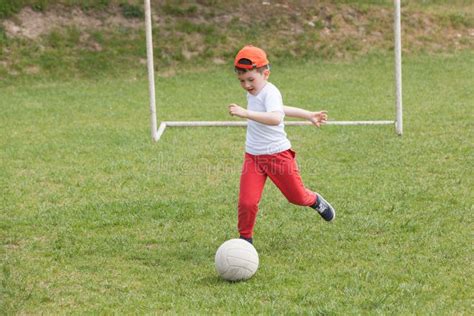 Ragazzino Che Dà Dei Calci Alla Palla Nel Parco Giocar a Calcioe Calcio