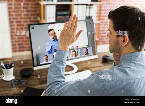 Raising Hand To Ask Questions In Training Video Conference Stock Photo