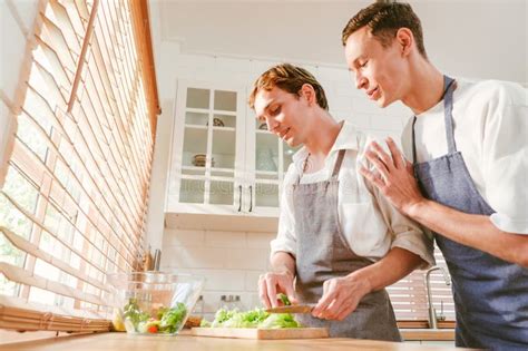 Happy Caucasian Gay Couple Making Salad Together One Person Used A Knife To Cut Lettuce In Front