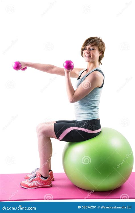 Pretty Brunette Exercising With Dumbbells On Fitness Ball Stock Image