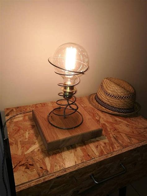 A Lamp Sitting On Top Of A Wooden Table Next To A Hat