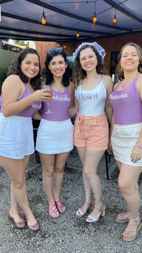 Four Women In Purple And White Outfits Posing For The Camera With One