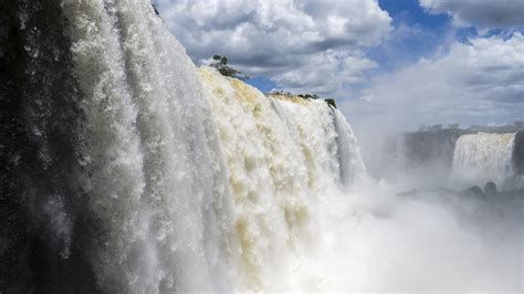 Wallpaper Waterfalls Under Cloudy Sky During Daytime Background