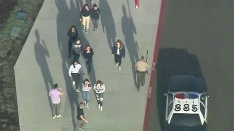 Law Enforcement Officers Search For Suspect In High School Shooting In