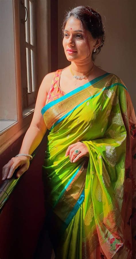 A Woman Wearing A Green And Yellow Sari