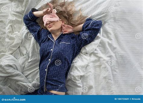 Cute Blonde In Her Bed In Blue Pajamas And Sleep Mask Stock Image