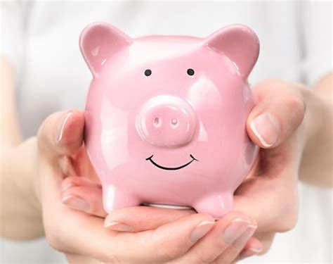 Premium Photo Female Hands Hold A Piggy Bank Closeup The Concept Of