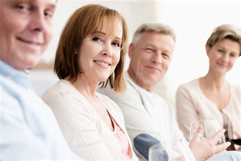 Portrait Of Smiling Mature Friends Sitting At Home Stock Photo Image Of Laptop Women