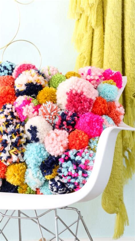 A White Chair Covered In Multicolored Pom Poms