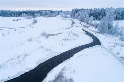 Aerial Of A Frosty And Snowy Rural Landscape With A Open River In