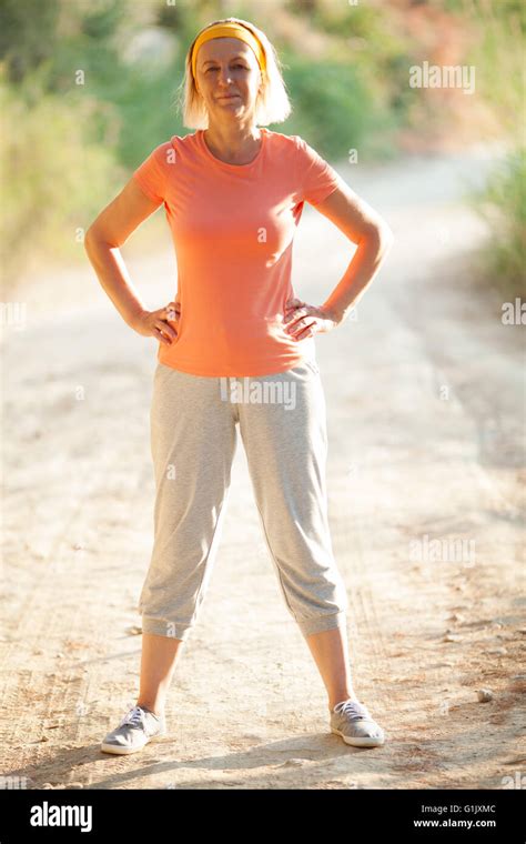 Mature Woman Standing With Hands On Hips On Road Stock Photo Alamy