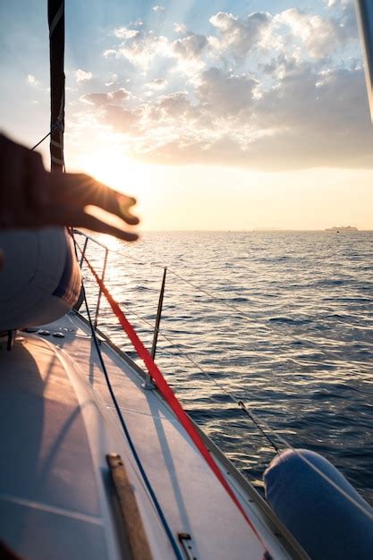 Barco a vela navegando no mar contra o céu durante o pôr do sol Foto