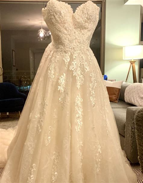 A Wedding Dress On Display In Front Of A Mirror