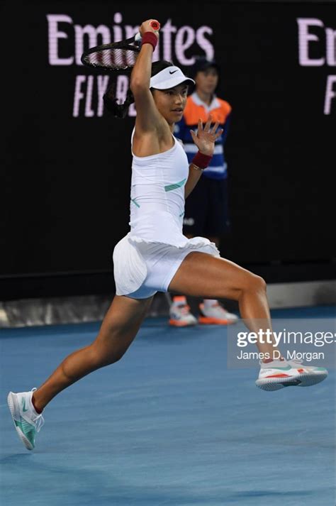 A Female Tennis Player In Mid Air After Hitting The Ball With Her Racquet