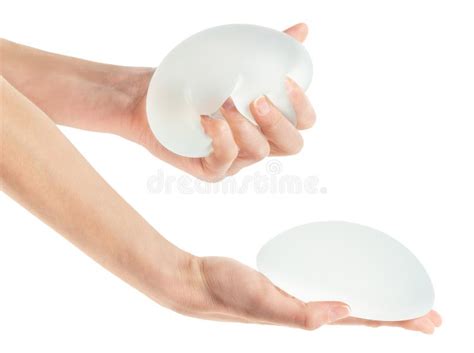 Female Squeezing Breast Implant In Hand On White Background With