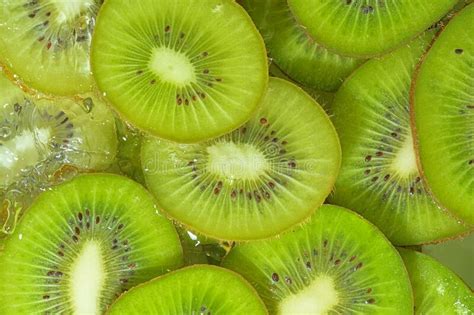 Close Up View Of The Green Kiwi Fruit Slices In Water Background