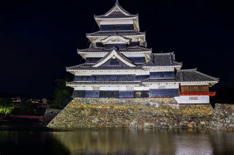 Ancient Japanese Matsumoto Castle At Night With A Reflection In The