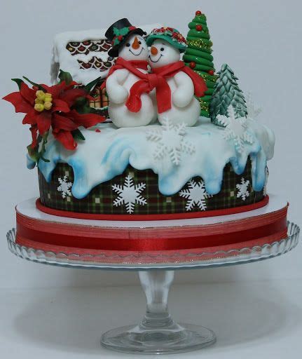 A Christmas Cake Decorated With Snowmen And Poinsettis On A Platter