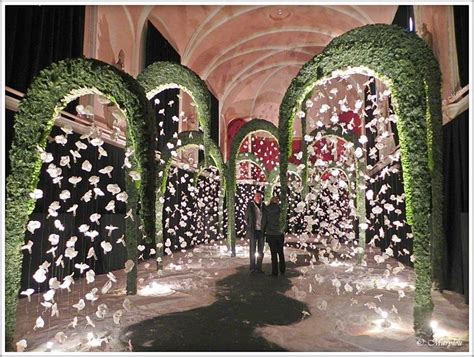 A Man Standing In Front Of An Archway Decorated With Flowers And