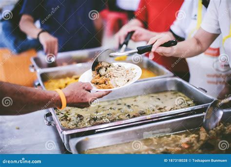 The Hands Of The Poor Receive Food That Volunteers Share To Alleviate