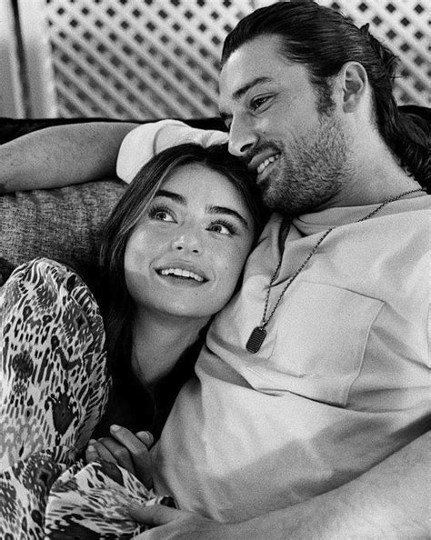 A Man And Woman Laying On Top Of A Couch Next To Each Other Smiling At