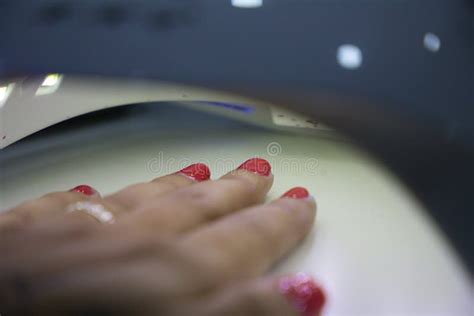 Woman S Hand Drying Her Freshly Polished Nails Under Ultraviolet Lamp