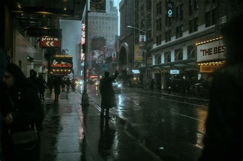 People Walking Down The Street On A Rainy Day In New York City At Night