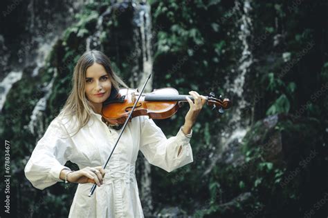 Talented Caucasian Woman Playing Violin Near Waterfall Music And Art