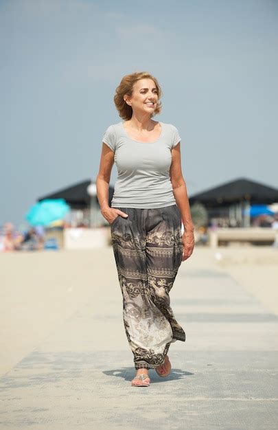 Premium Photo Meautiful Older Woman Walking At The Beach