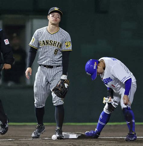 14日の中日戦、8回に田中の送りバントで、坂本の送球したボールを落球し、がっくりの佐藤輝（右は岡林）（撮影・椎名 航） ― スポニチ