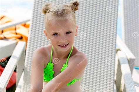 Jeune Fille Dans Un Maillot De Bain Sur Une étagère Par La Piscine