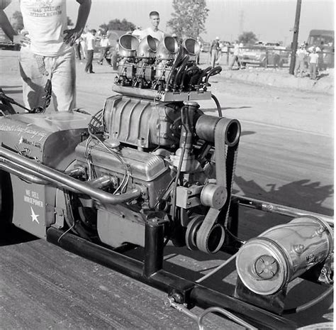 an engine on the back of a truck with two men in the background looking at it