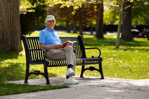 Free Photo Senior Man Sitting On A Bench Outdoors And Reading Book