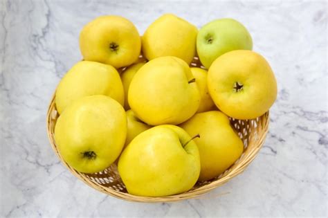 Premium Photo Wicker Basket With Golden Green Apples