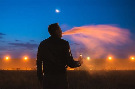 Premium Photo The Man Smoke Electronic Cigarette Near The Building