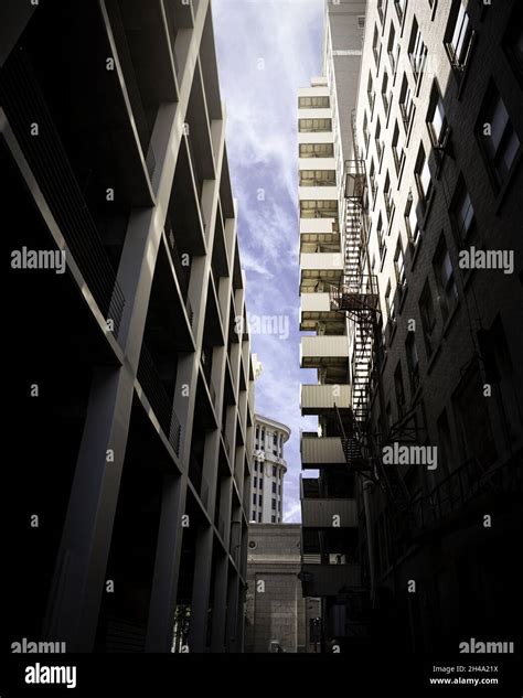 Vertical Low Angle Shot Of A Narrow Lane Between Buildings Stock Photo