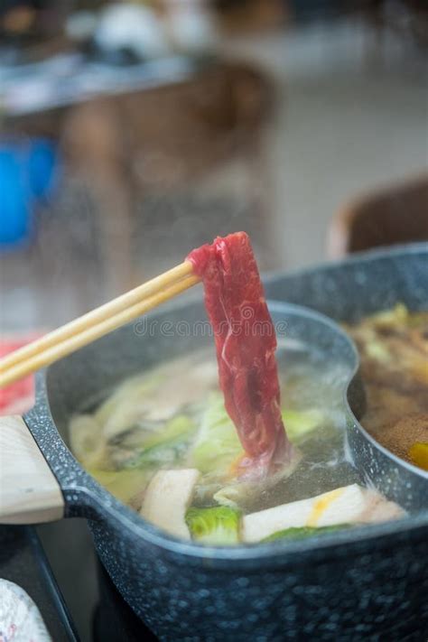 Man Holding Sliced Beef Meat By Chopsticks Shabu Shabu Is Japanese Style Beef In A Hot Pot Dish