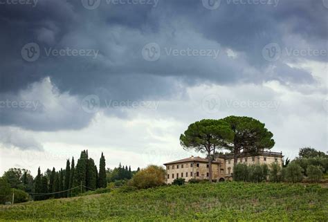 Tuscan Hillside Panorama With Cloudy Sky And Typical Local Habitation